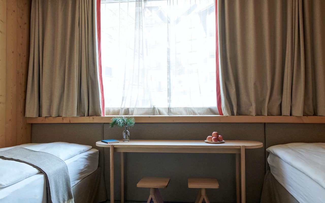 Twin Zimmer im Hotel Carina Zermatt mit zwei Einzelbetten und Fensterbank.