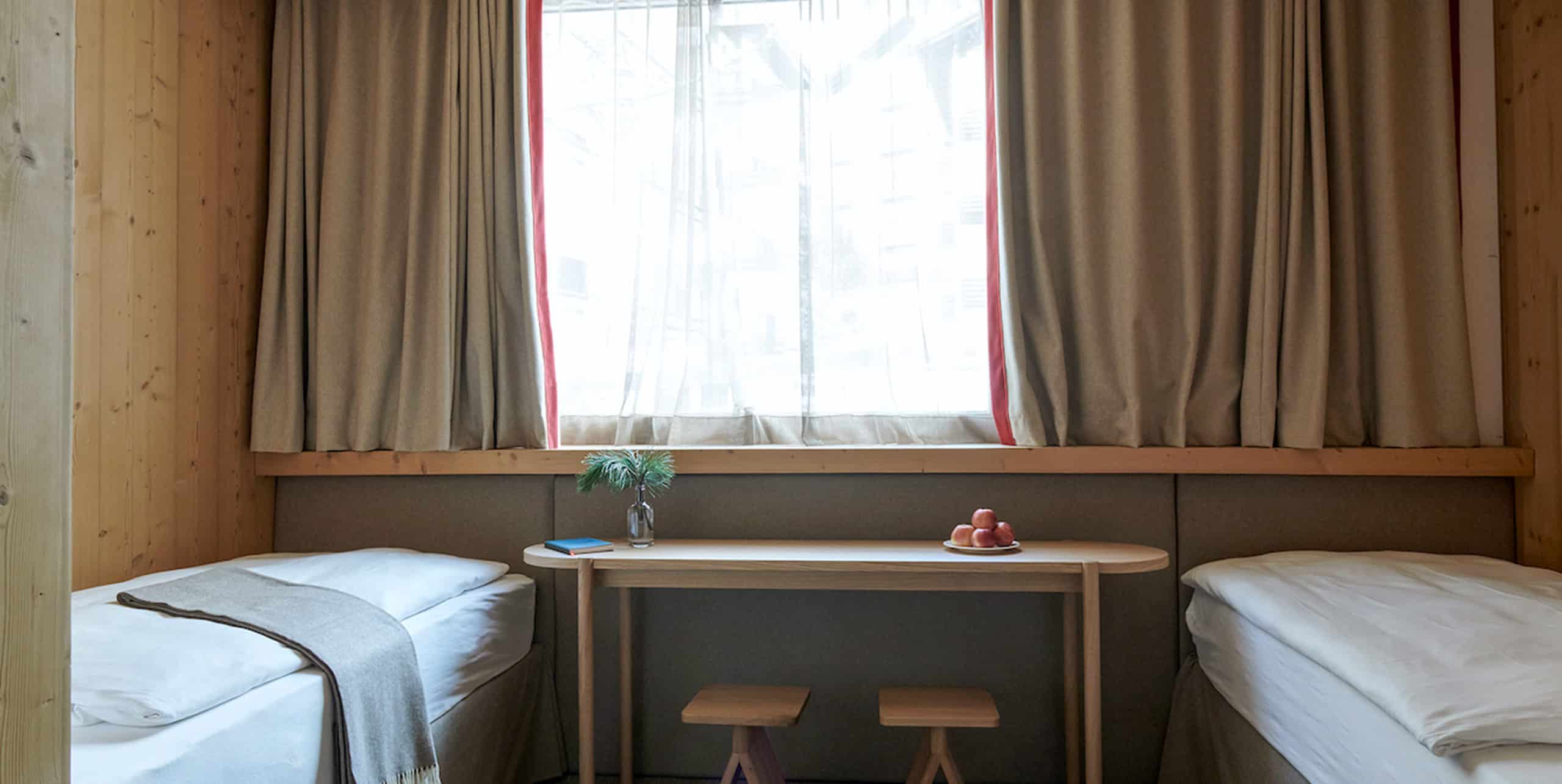 Twin Zimmer im Hotel Carina Zermatt mit zwei Einzelbetten und Fensterbank.
