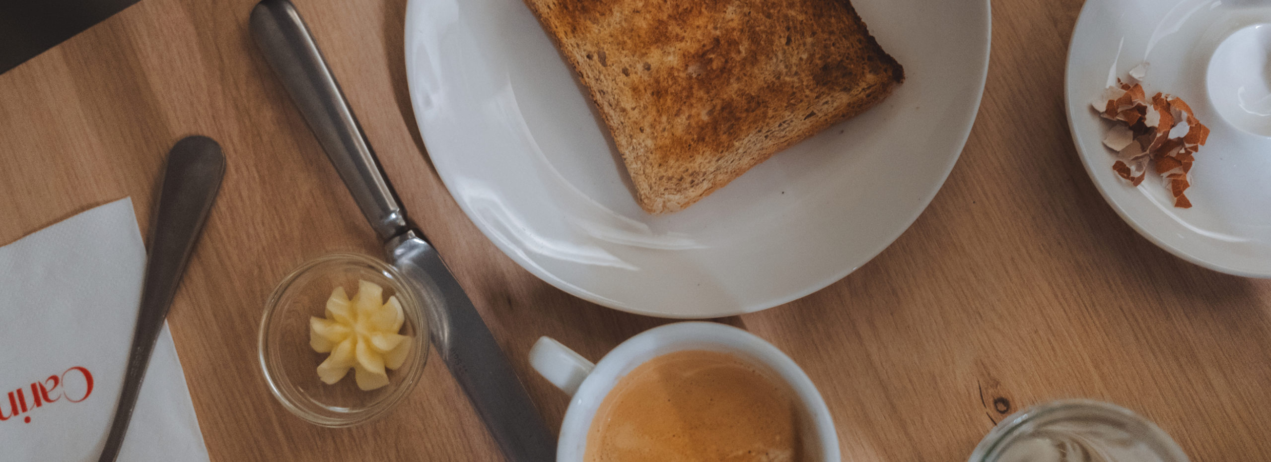 Table de petit-déjeuner à l’Hôtel Carina Zermatt avec café, toast et beurre