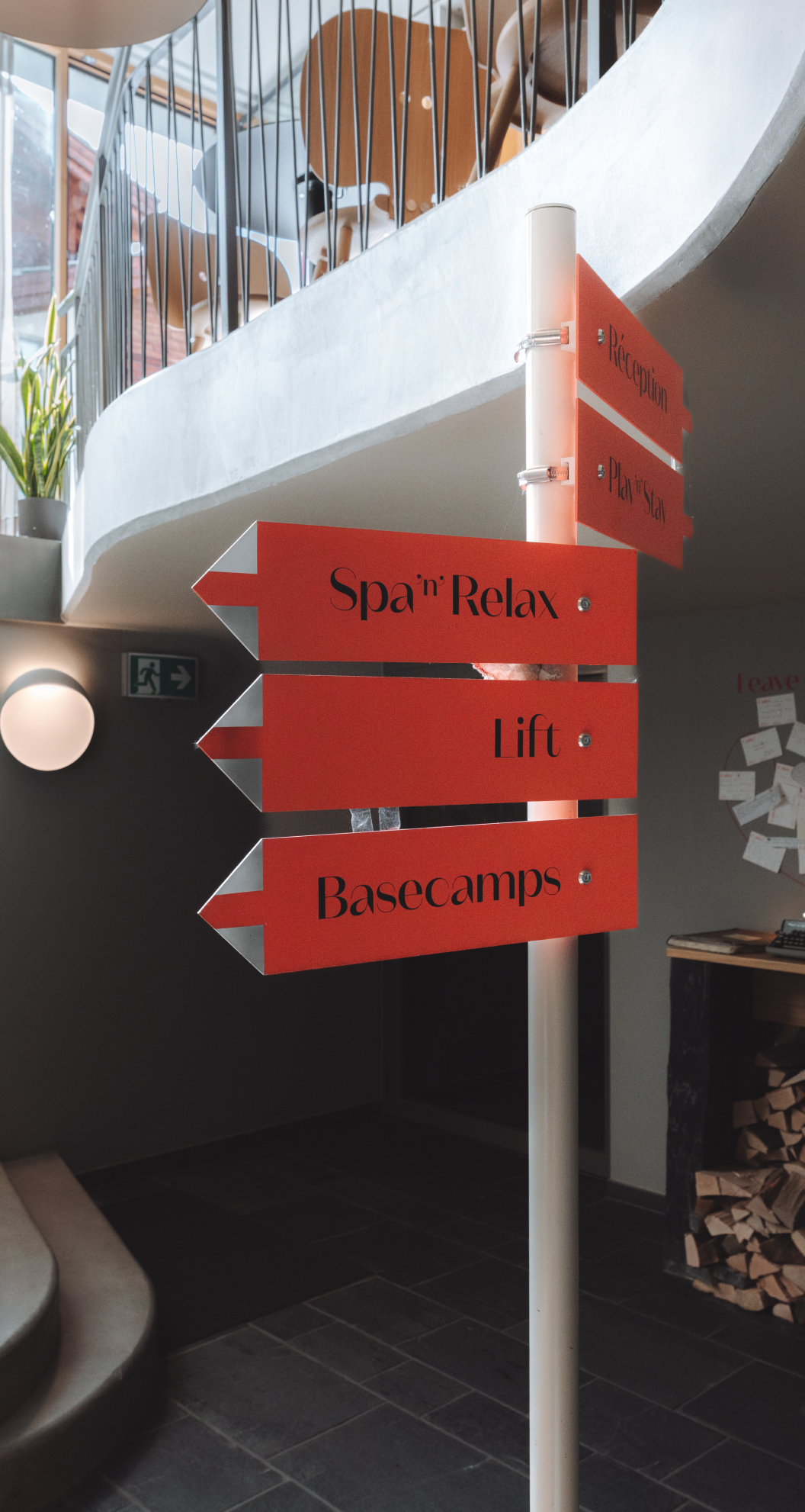 Panneau directionnel rouge à l’intérieur indiquant Spa & Relax, Lift et Basecamps.