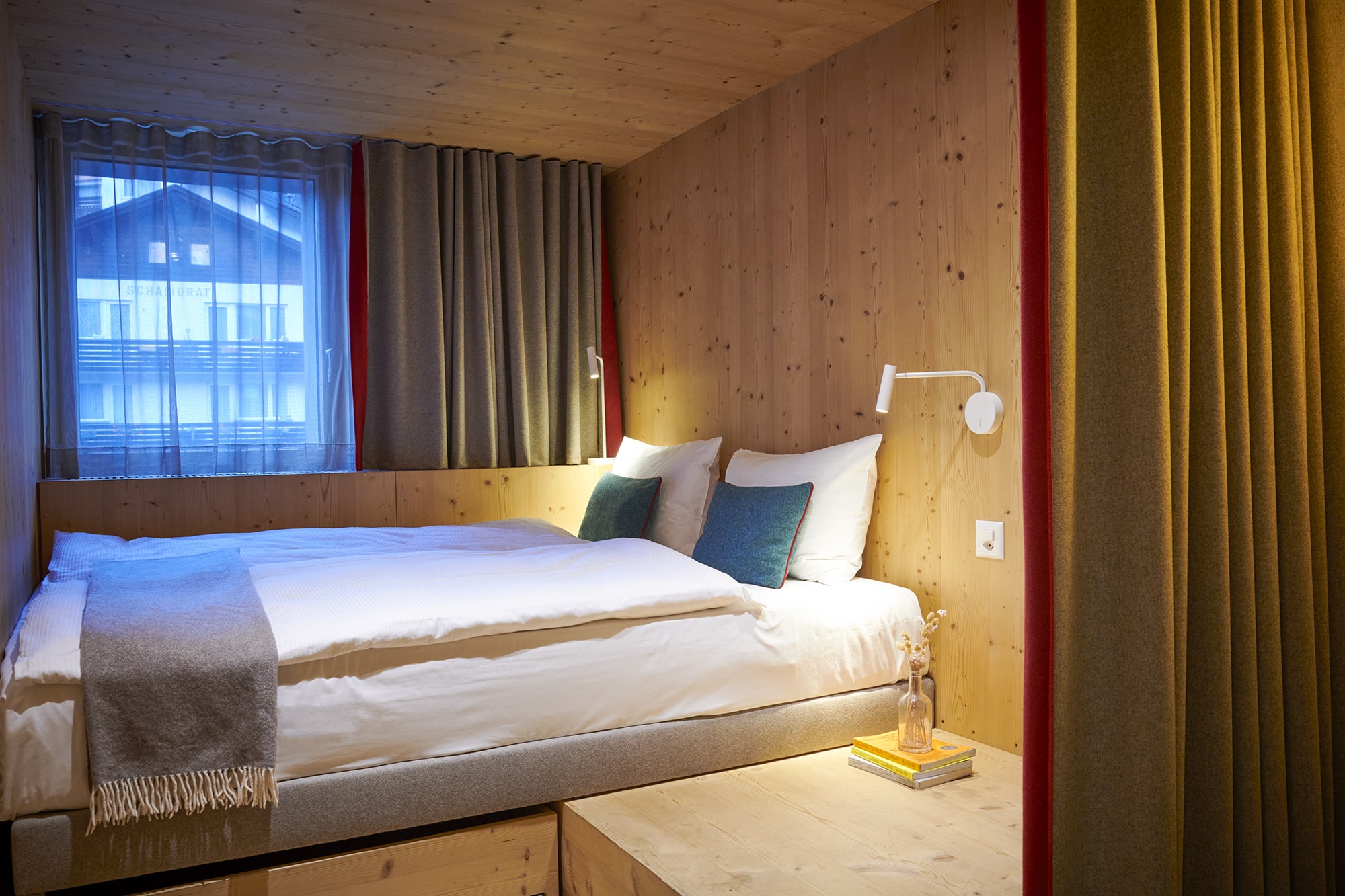 Chambre Double Cocoon à l’Hôtel Carina Zermatt avec lit double confortable et intérieur alpin en bois.