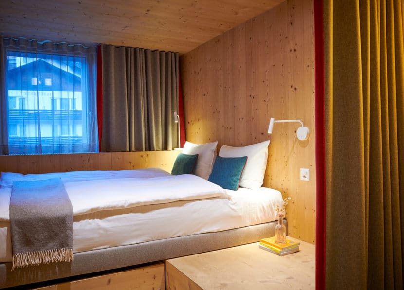 Double Cocoon room at Hotel Carina Zermatt featuring a cozy double bed and alpine wooden interior.