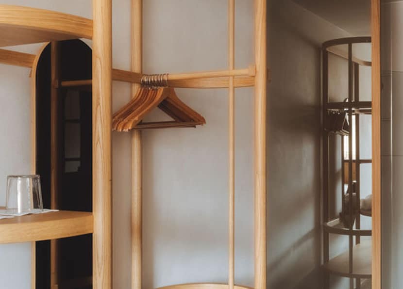 Open wooden wardrobe in the Double Cocoon room at Hotel Carina Zermatt.