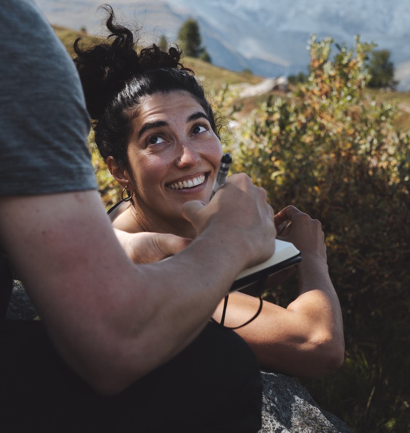Lachender Moment zwischen zwei Menschen während einer Pause in der Natur bei Zermatt.