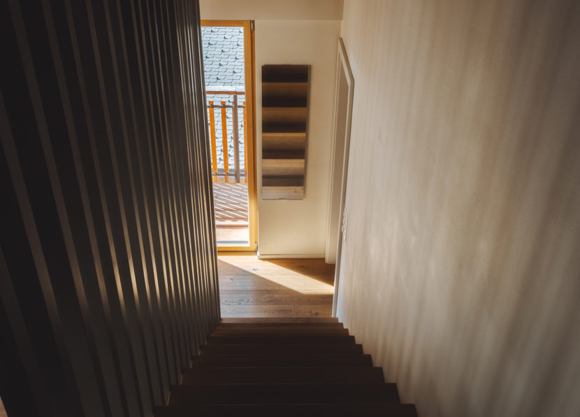 Staircase in the Penthouse Matterhorn at Hotel Carina Zermatt with natural light and balcony access
