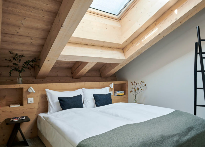 Bedroom of the Penthouse Matterhorn at Hotel Carina Zermatt with skylight and ladder detail