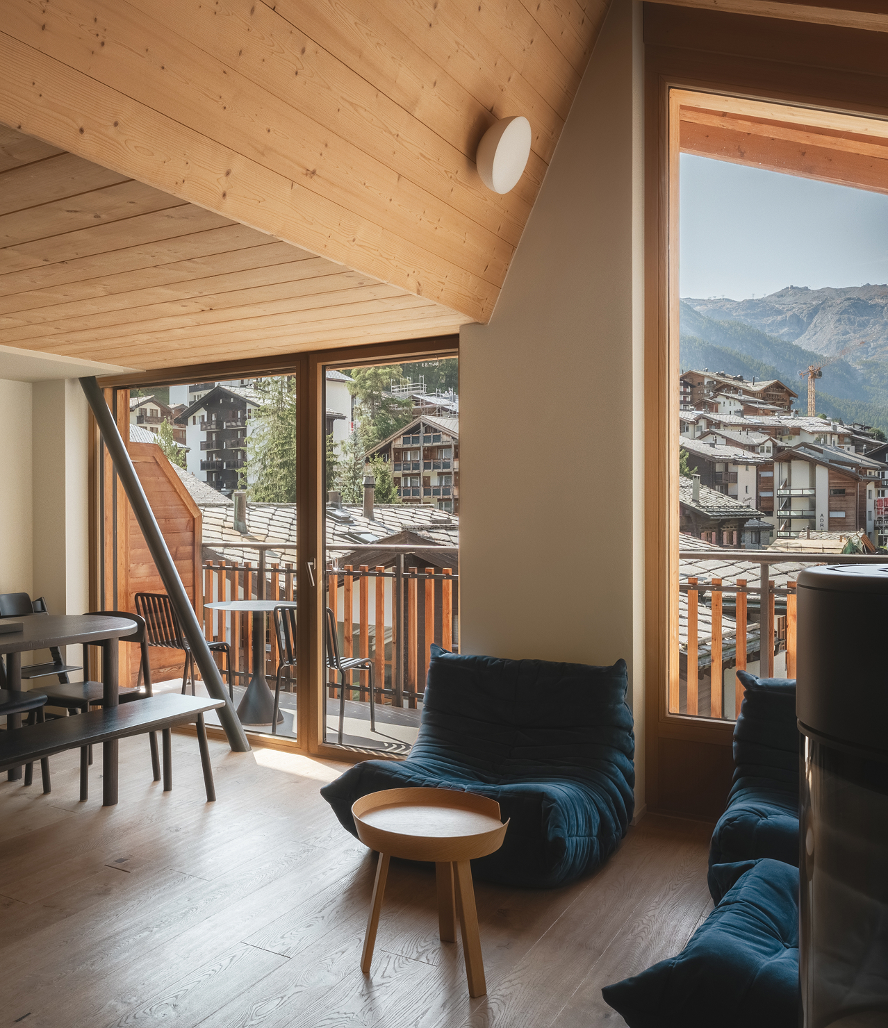 Coin salon du Penthouse Matterhorn à l’Hôtel Carina Zermatt avec vue sur le village et les montagnes