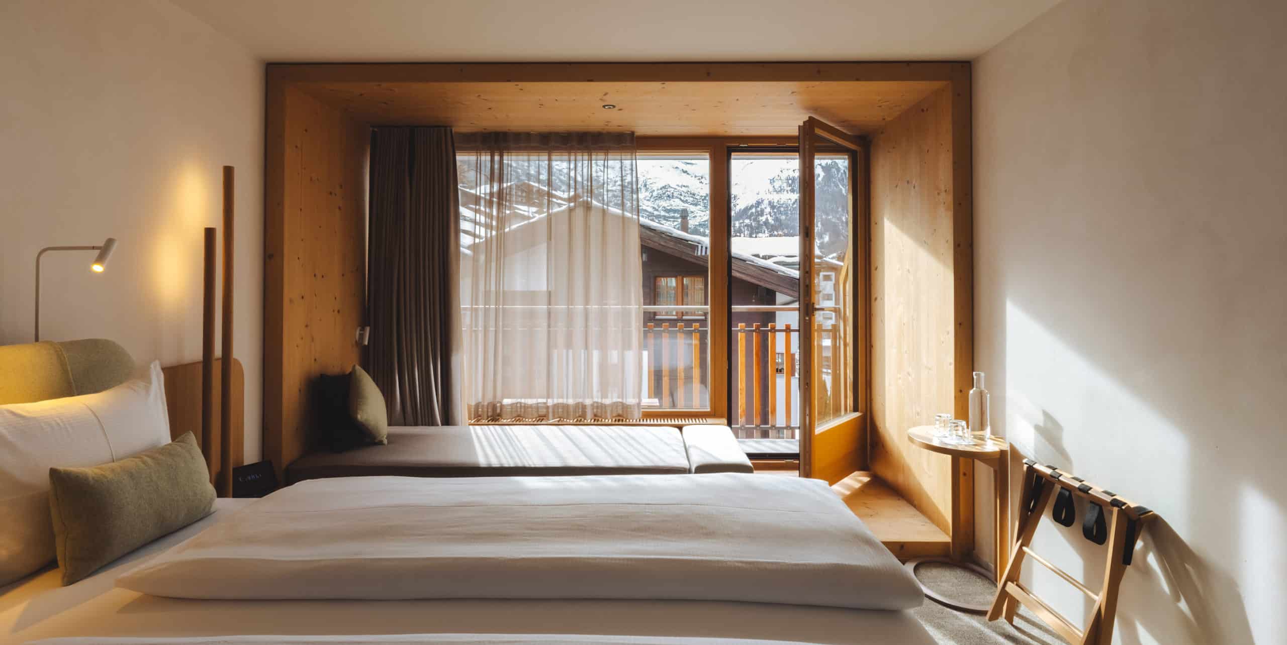 Heroaufnahme des Matterhorn Deluxe Zimmers mit Balkontür und Bergblick im Hotel Carina Zermatt.