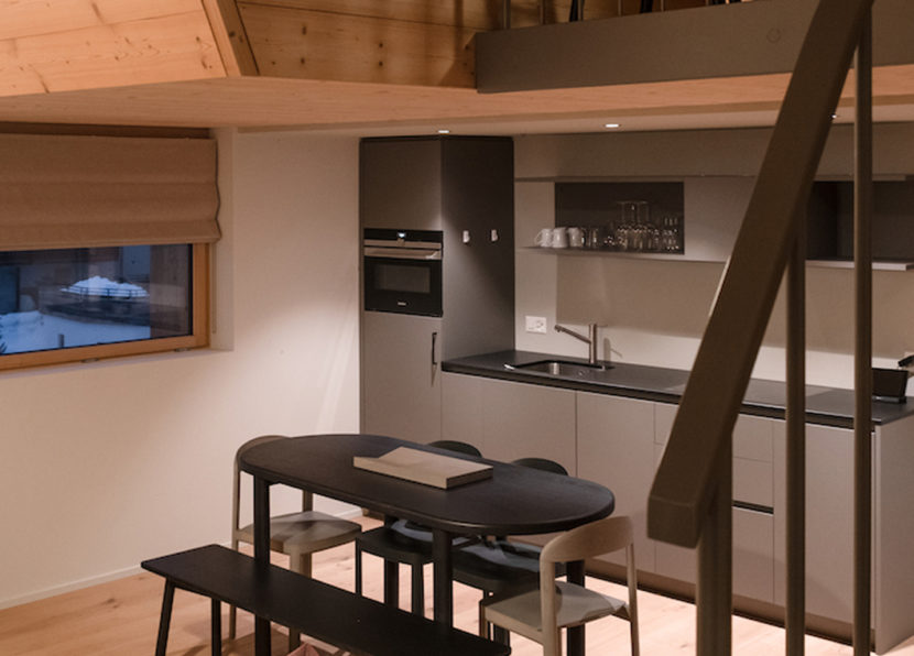 Kitchen and dining area of the Penthouse Matterhorn at Hotel Carina Zermatt with modern amenities