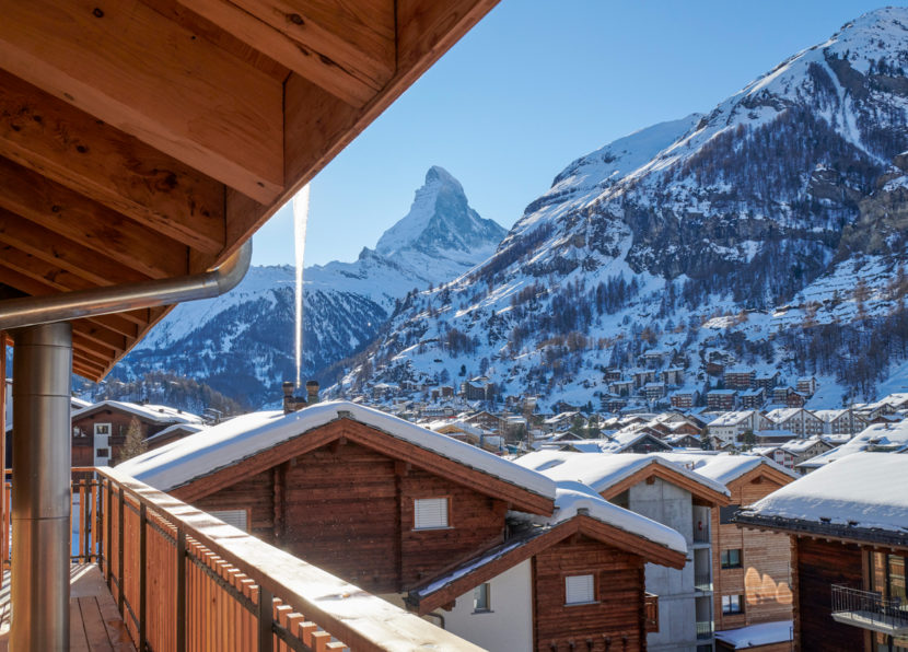 Balcony view over snow-covered chalets with the Matterhorn in the background